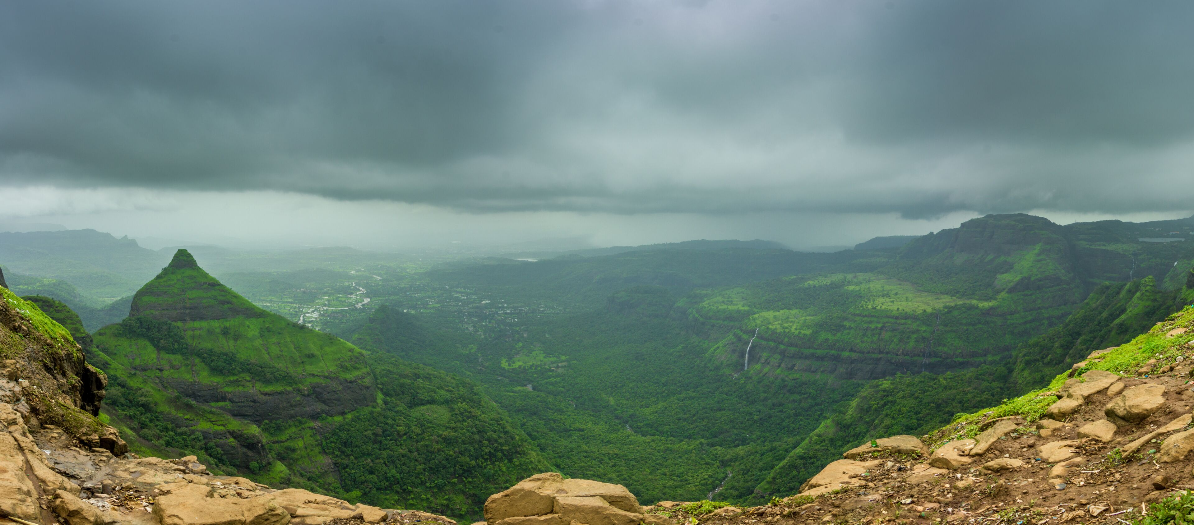 A mountainous landscape with lush green valleys and a river winding through the terrain.