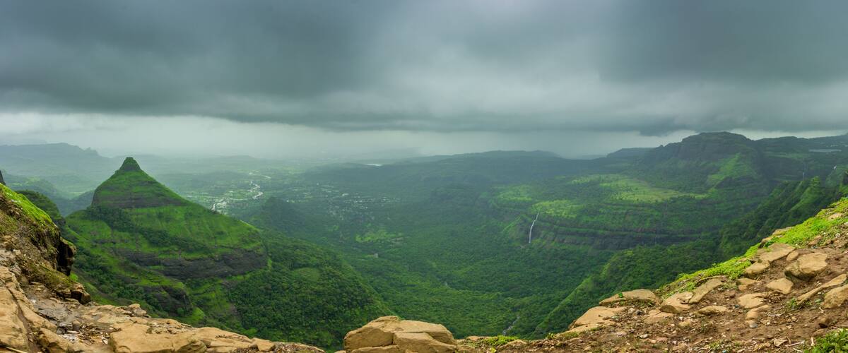 A mountainous landscape with lush green valleys and a river winding through the terrain.