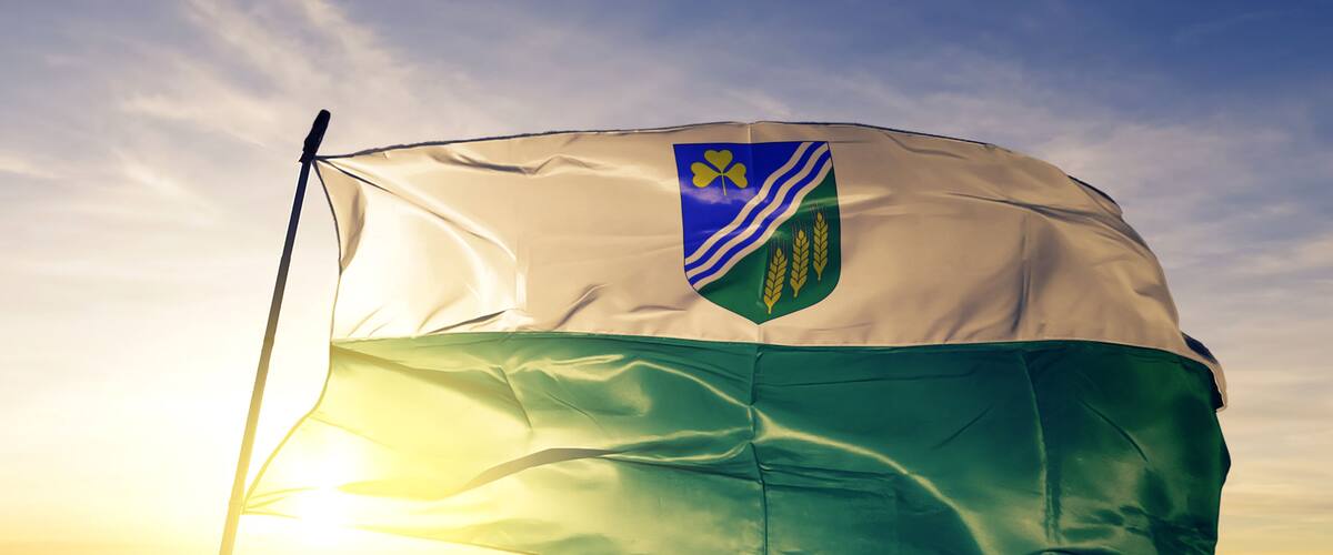 Jogeva county of Estonia flag waving on the top sunrise mist fog