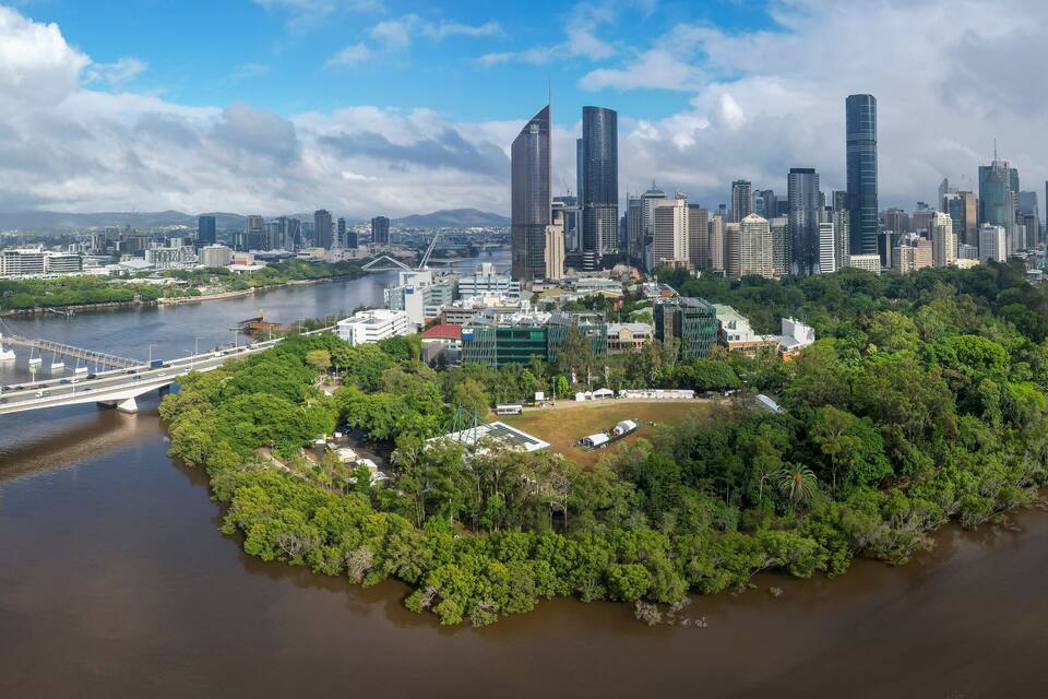 A city skyline with modern skyscrapers, a river, and a bridge.