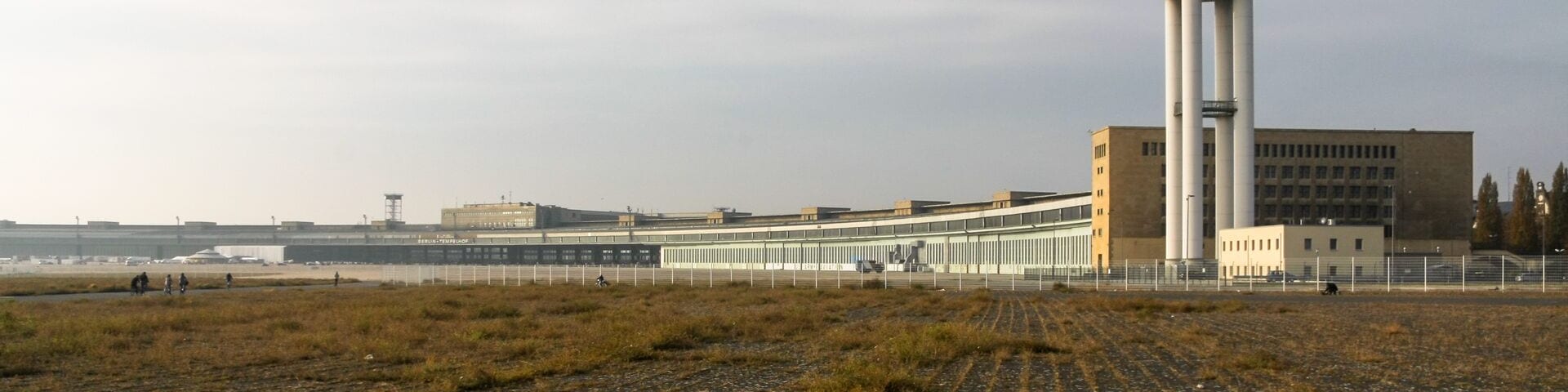 Ehemaliger Flughafen Berlin-Tempelhof vom Nördlichen Teil des Flugfeldes Ausgesehen. Vorne rechts der Radarturm, hinten links das Hauptgebäude mit dem Vorfeld.