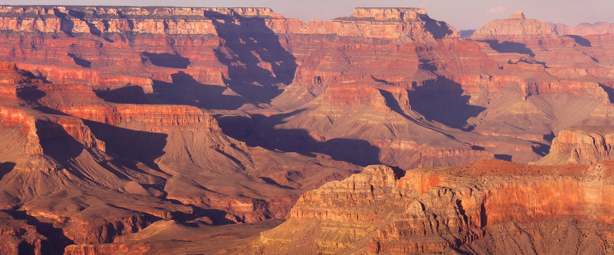 A vast canyon with layered rock formations and deep valleys.
