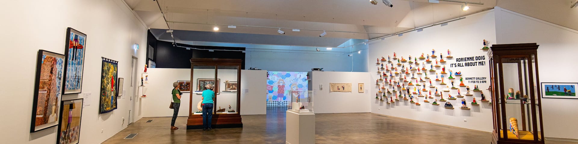 Una galería de arte con pinturas y esculturas expuestas.