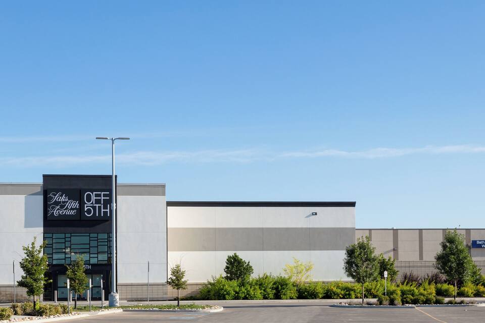 En moderne bygning med et skilt, der siger "Saks Fifth Avenue OFF 5TH".