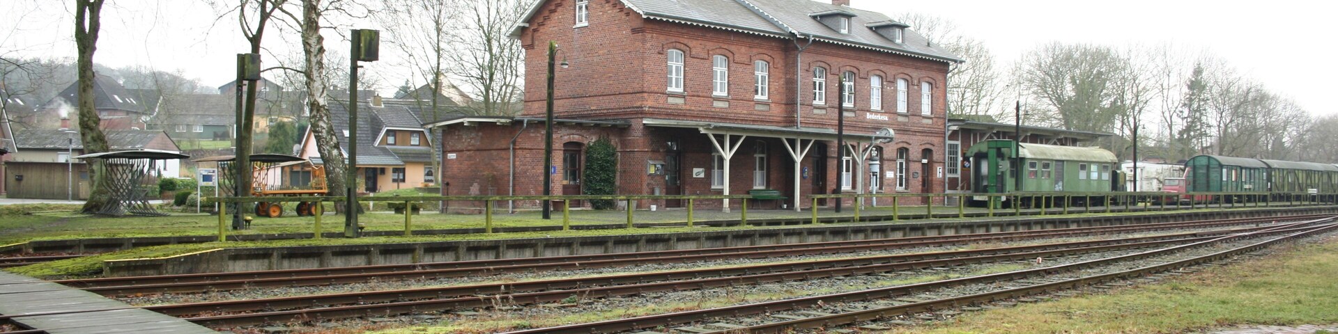 Bahnhofsgebäude, Bahnsteige und abgestellte Wagen im Bahnhof Bederkesa; Blick Richtung Südwesten