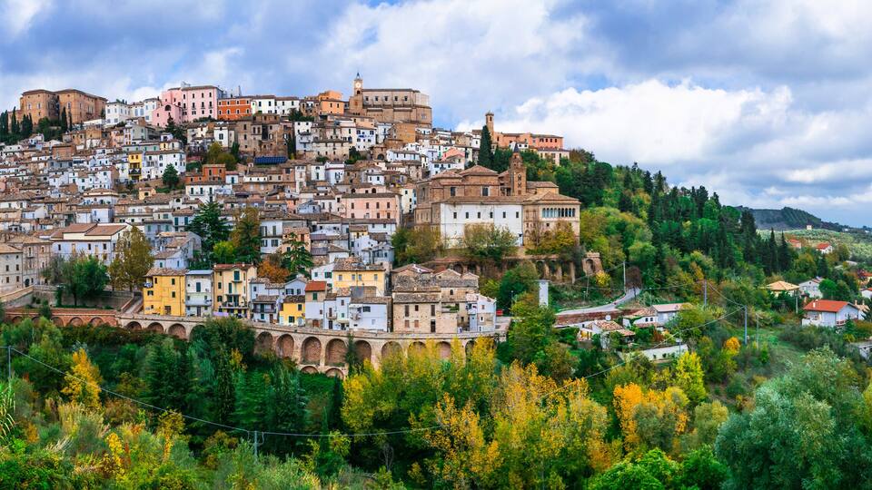 A densely packed hillside town with historic buildings and a prominent church tower.