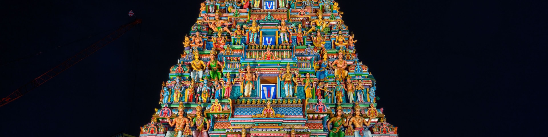 Um templo bem iluminado, com vários níveis, cada um decorado com estátuas coloridas e esculturas detalhadas.