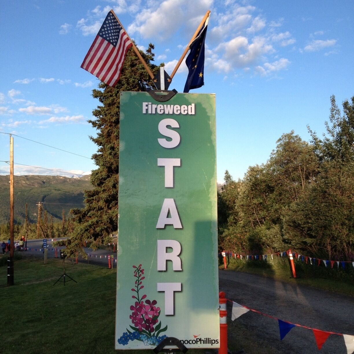 A green sign with 'Fireweed START' and flags.