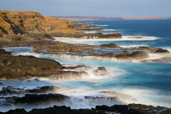 Phillip Island welches beinhaltet Wellen, Felsküste und Bucht oder Hafen