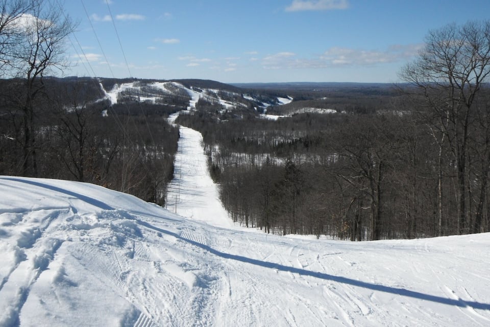A snowy mountain landscape with a ski trail.