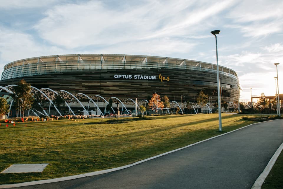 L'estadi Optus amb un sostre corbat, envoltat d'una zona verda i arbres.