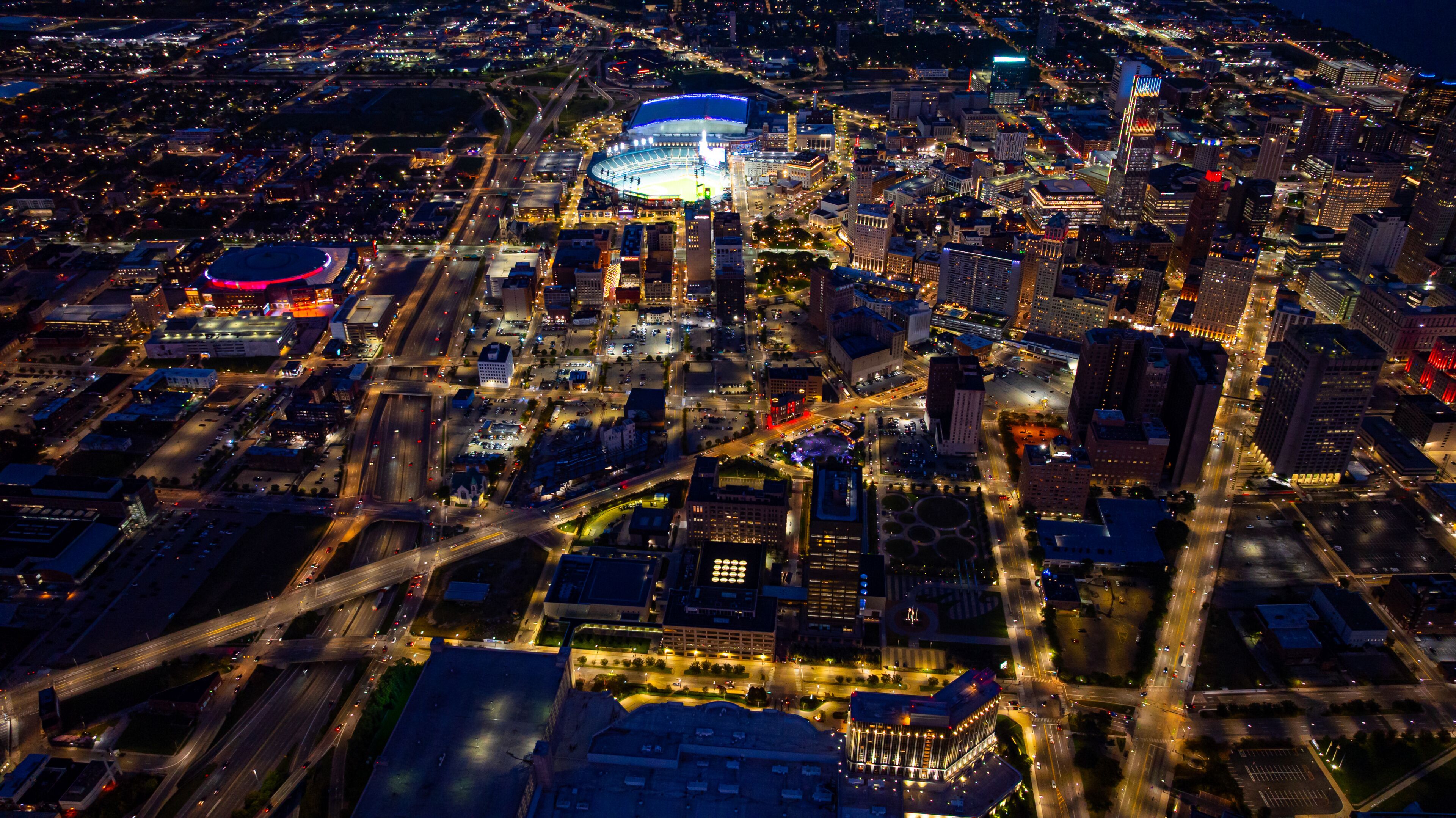 Detroit skyline aerial view at night. Drone night aerial photo of downtown Detroit city lights, Comerica Park, and Little Caesars Arena.