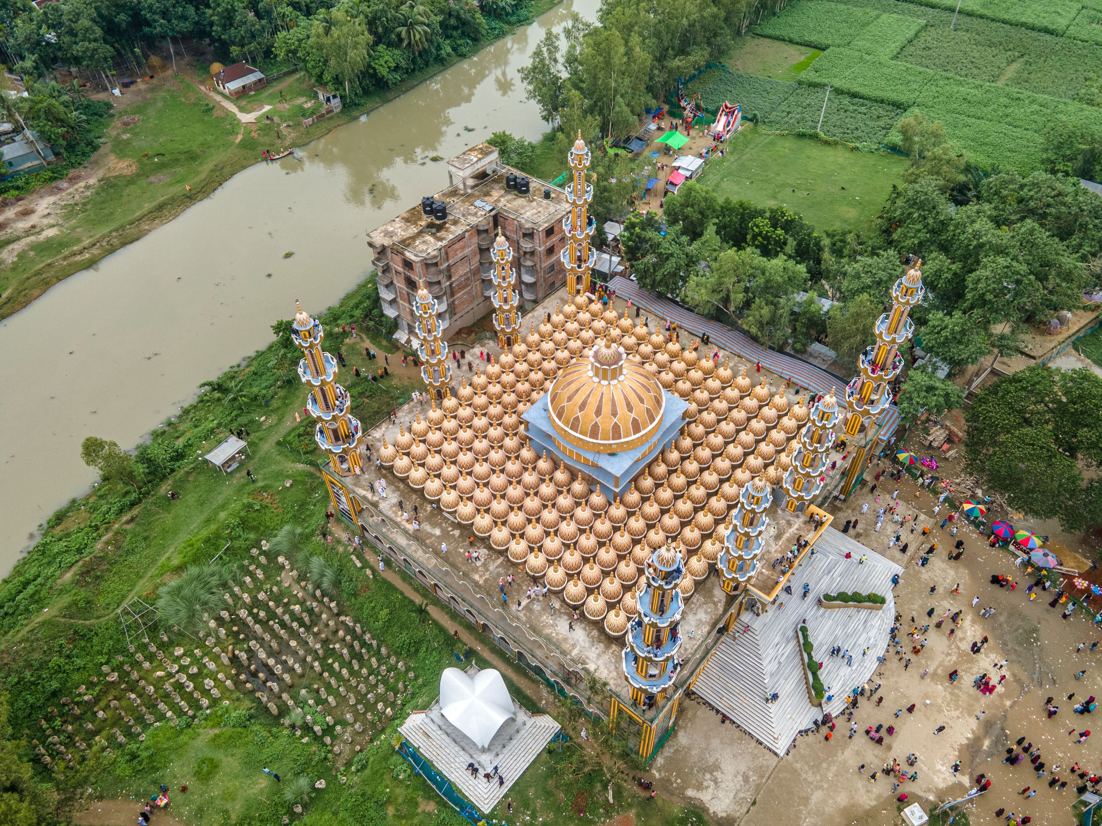 An aerial view of a temple complex with a large central dome, multiple smaller domes, and ornate towers.