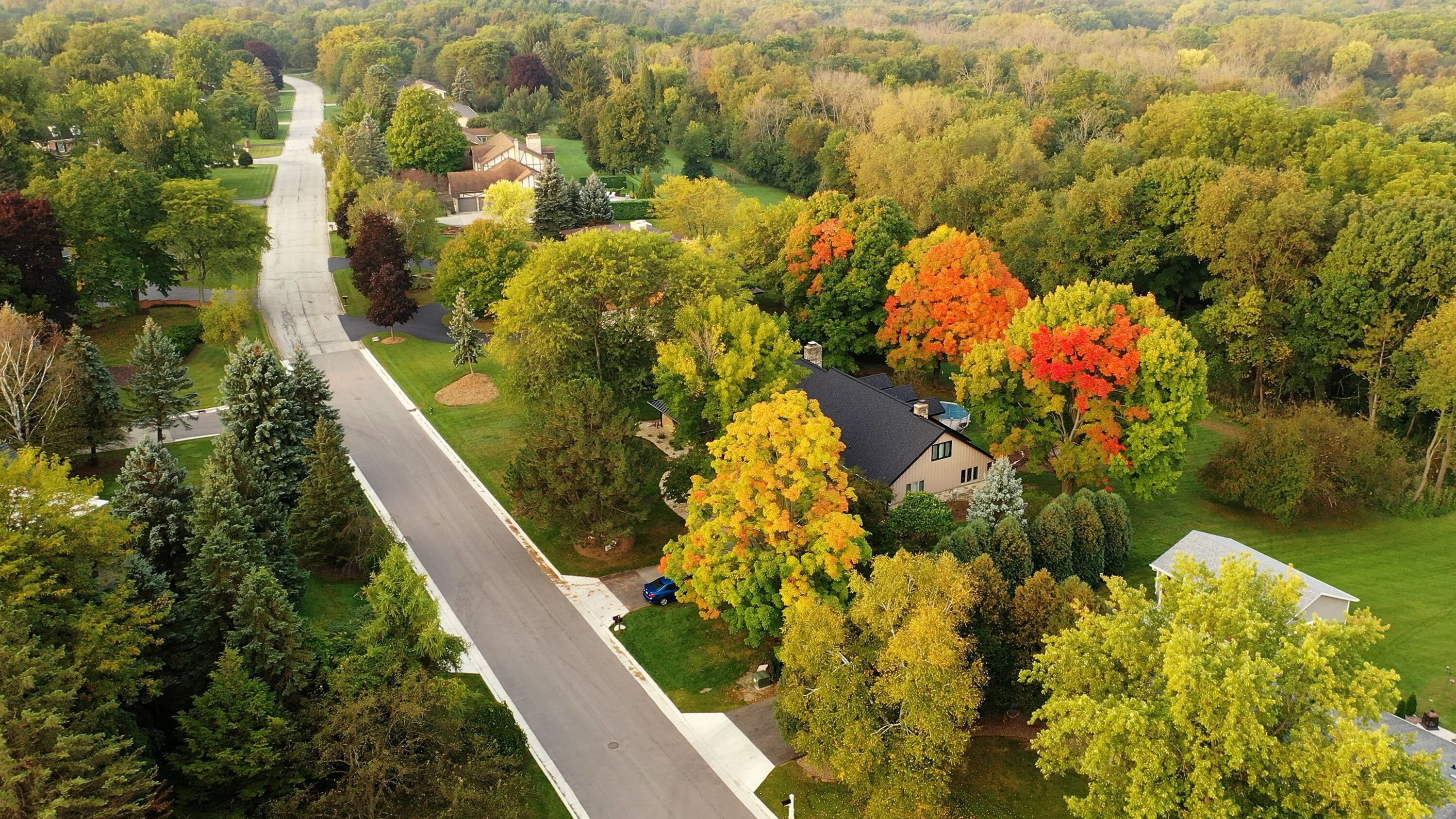 Aerial drone view of American suburban neighborhood. Establishing shot of America's  suburb. Residential single family houses pattern. Autumn Fall season