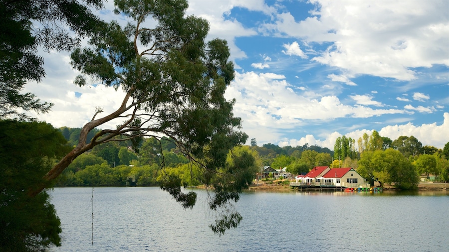 Un lago con una casa sobre pilotes y un muelle.