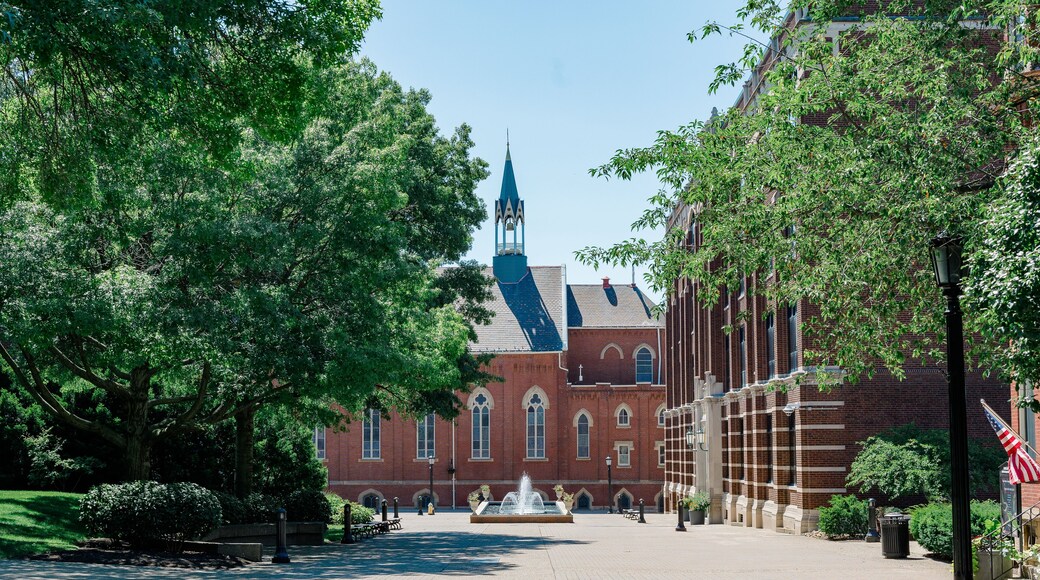 College campus with red brick church surrounded by trees and greenery.