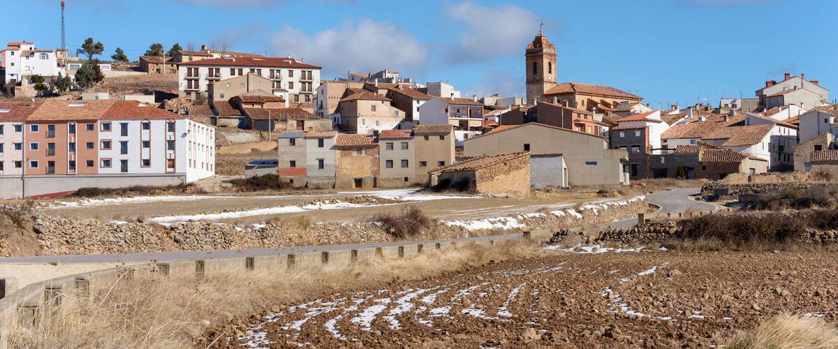 A town with a prominent church tower, terraced buildings, and a mix of modern and traditional architecture.