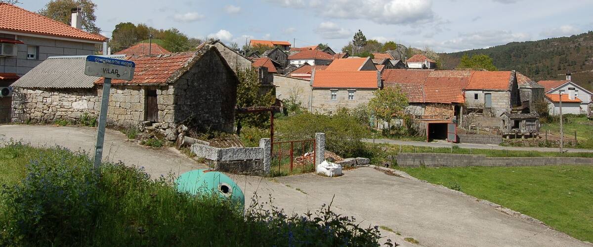 A rural village with stone houses and a sign reading "VILAR".