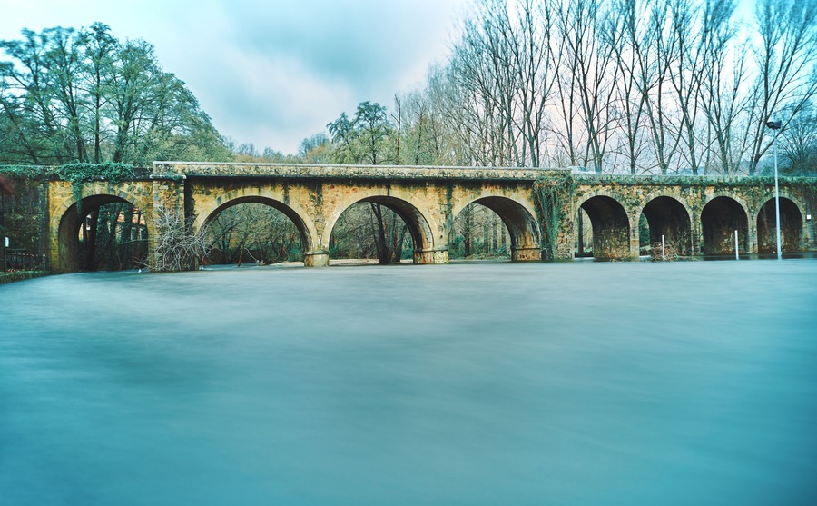 River with large water flow over a bridge in winter. The lake. Jaraíz de la Vera. Spain.