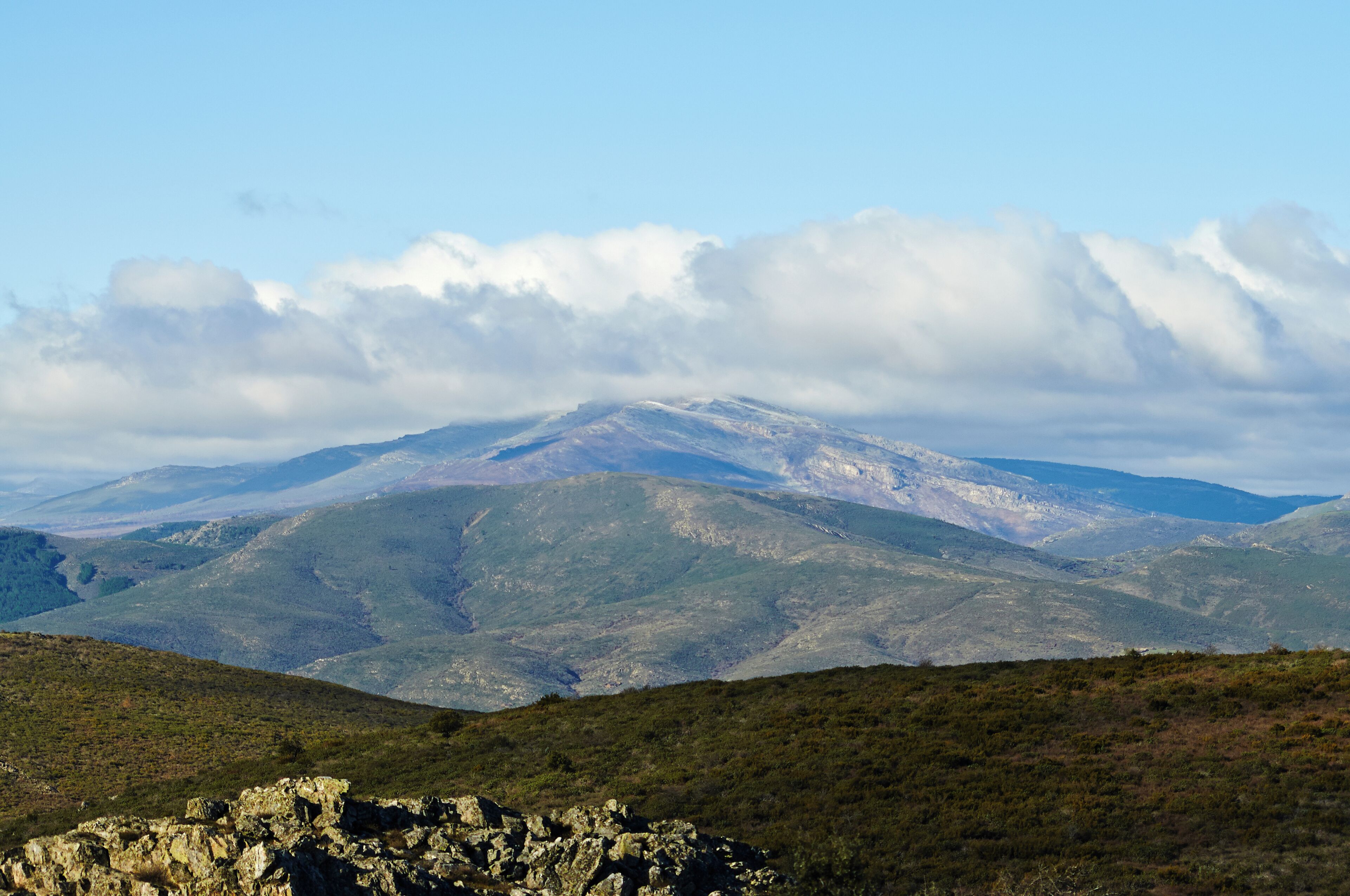A mountain range with snow-capped peaks and a clear sky.