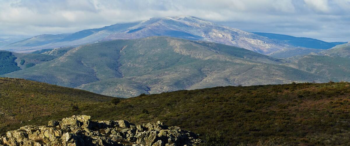 A mountain range with snow-capped peaks and a clear sky.