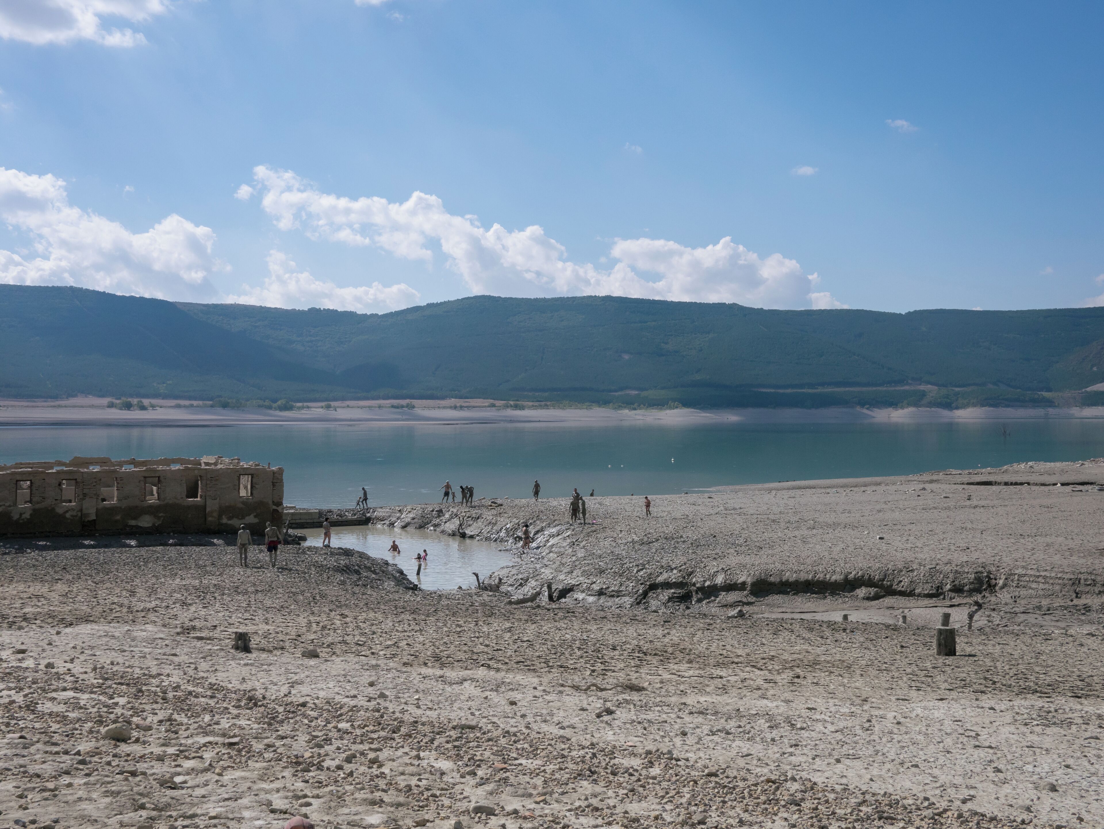 Low water level at the Yesa reservoir. People taking mud baths at the sulphurous waters of Tiermas. Area normally under water. Aragón, Spain