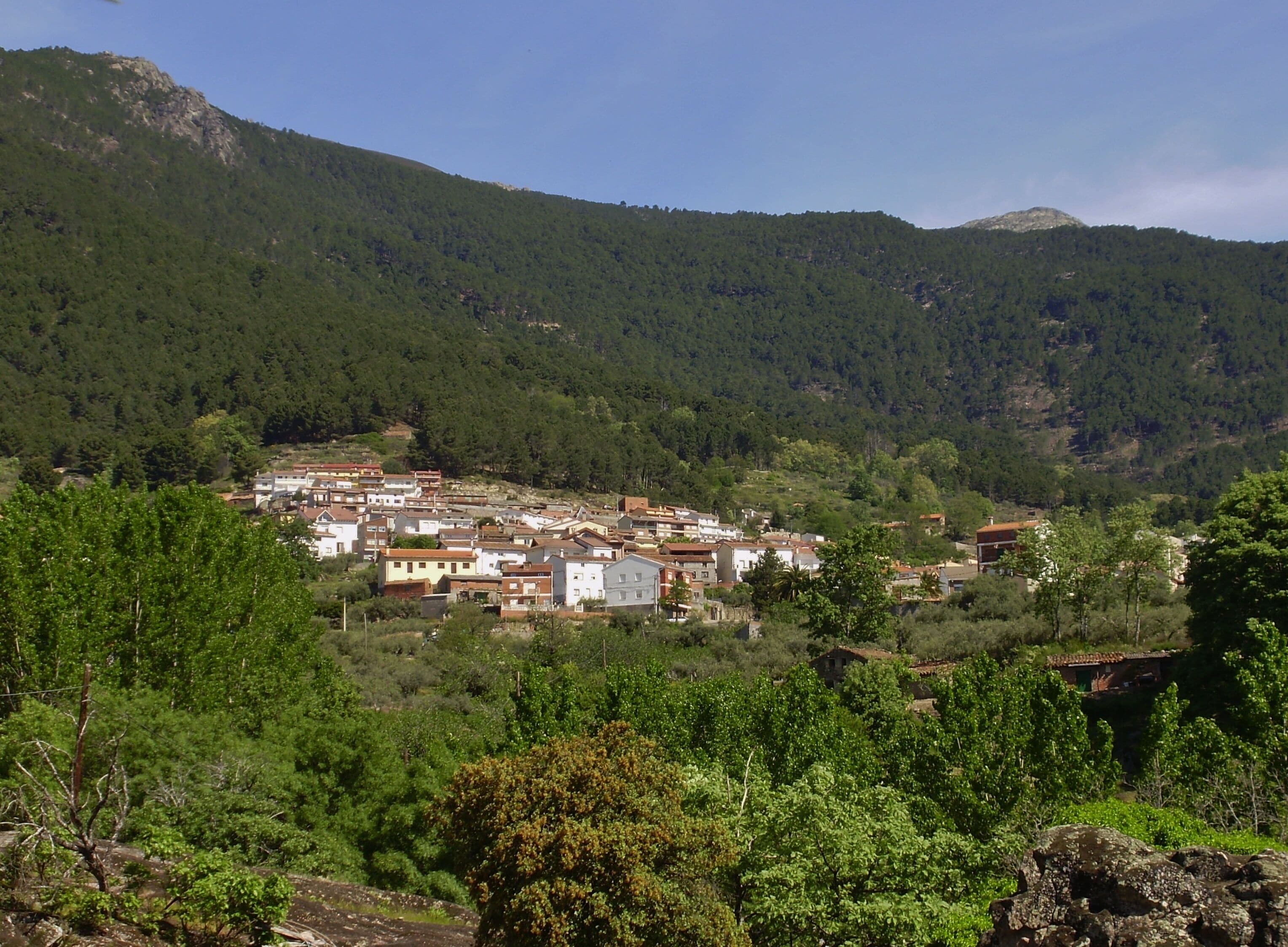 A village nestled in a valley surrounded by mountains.