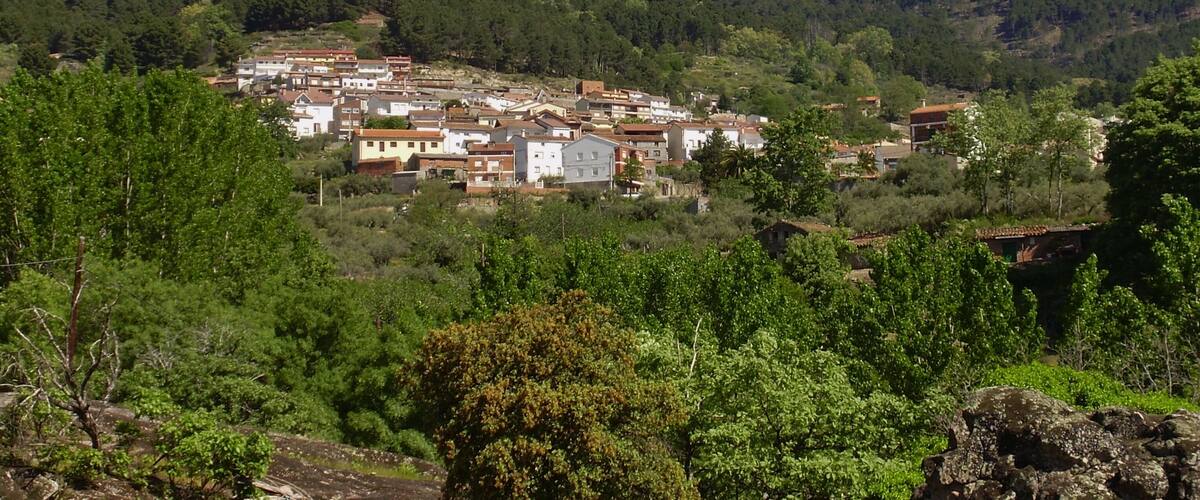 A village nestled in a valley surrounded by mountains.