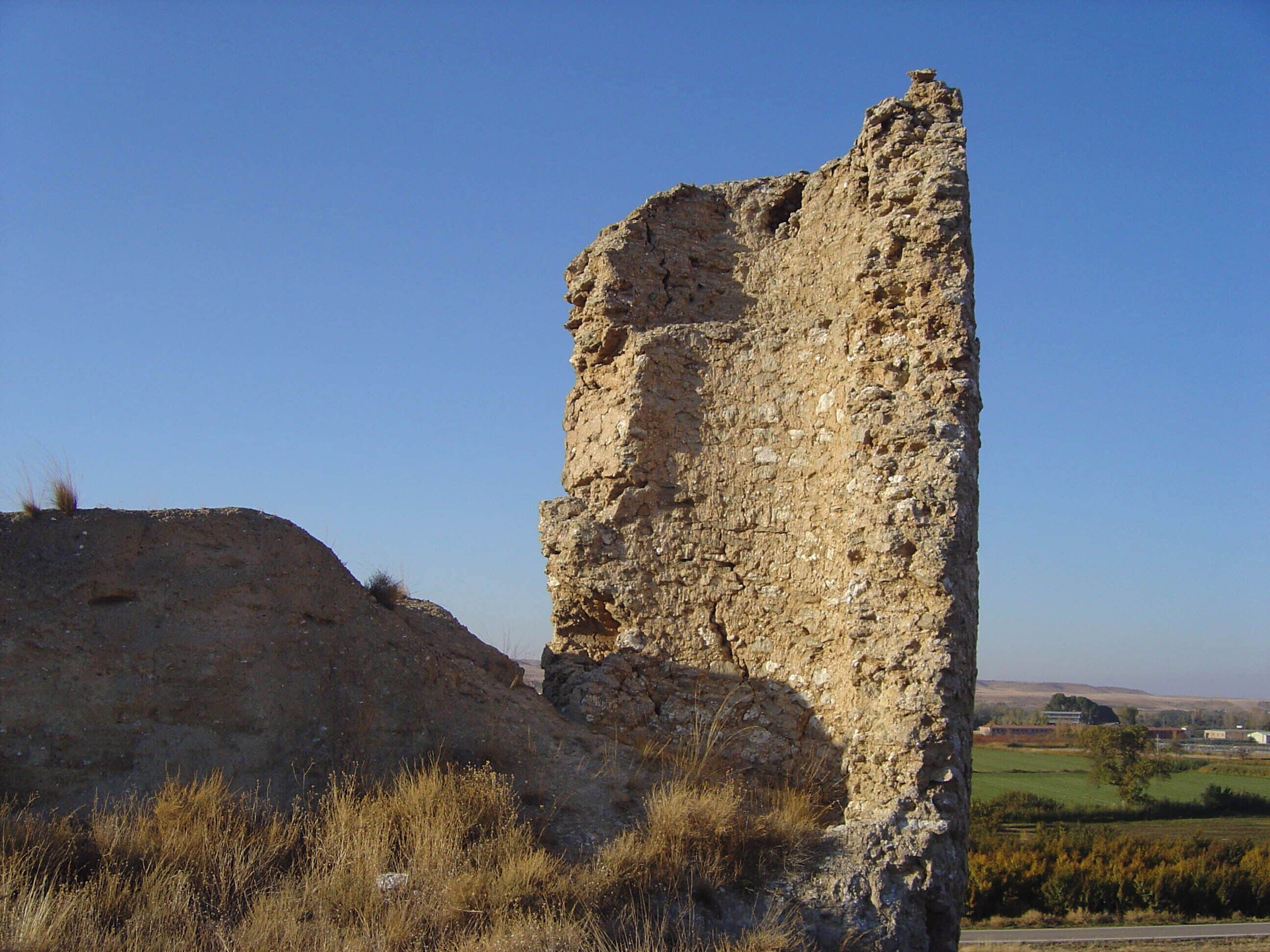 A tall, weathered stone structure in a rural landscape.