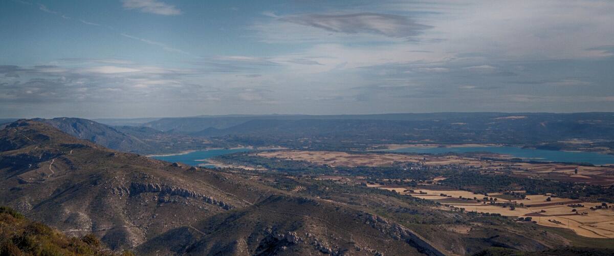 A mountainous landscape with a valley and a lake.