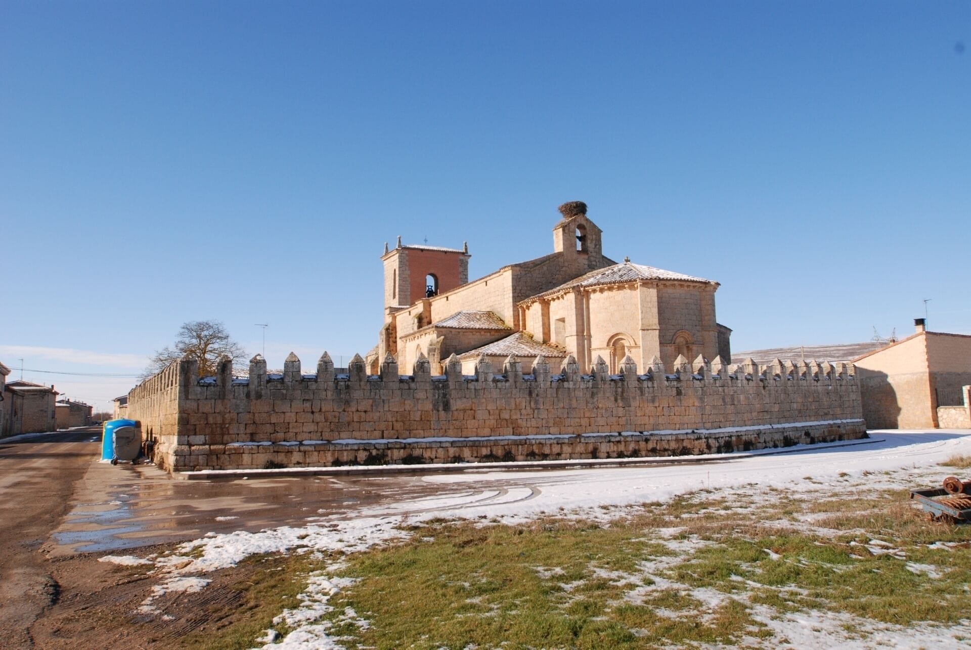 A historic church with a bell tower and a fortified wall.