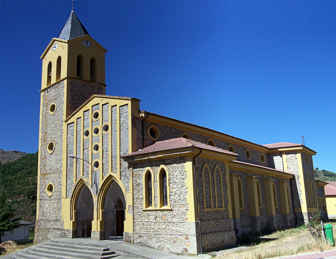 A church with a bell tower, arched windows, and a stone facade.