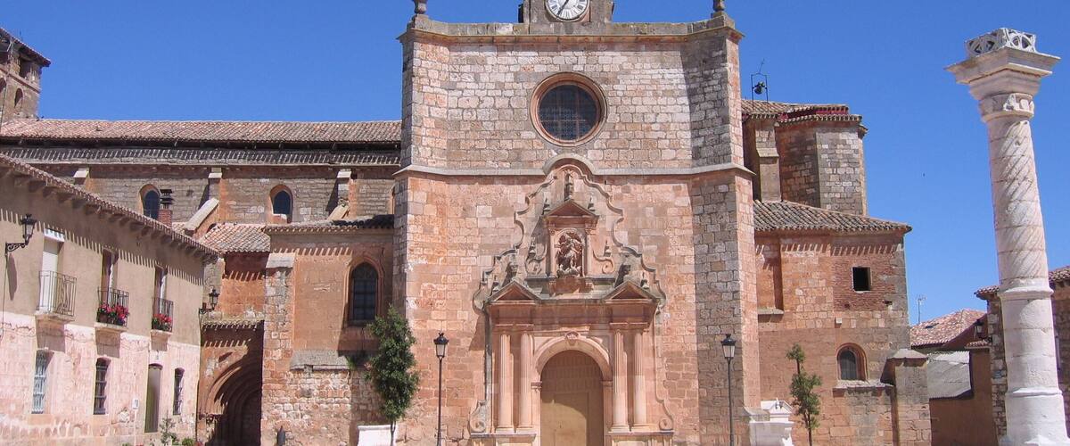 A historic church with a clock tower, arched windows, and a central doorway.