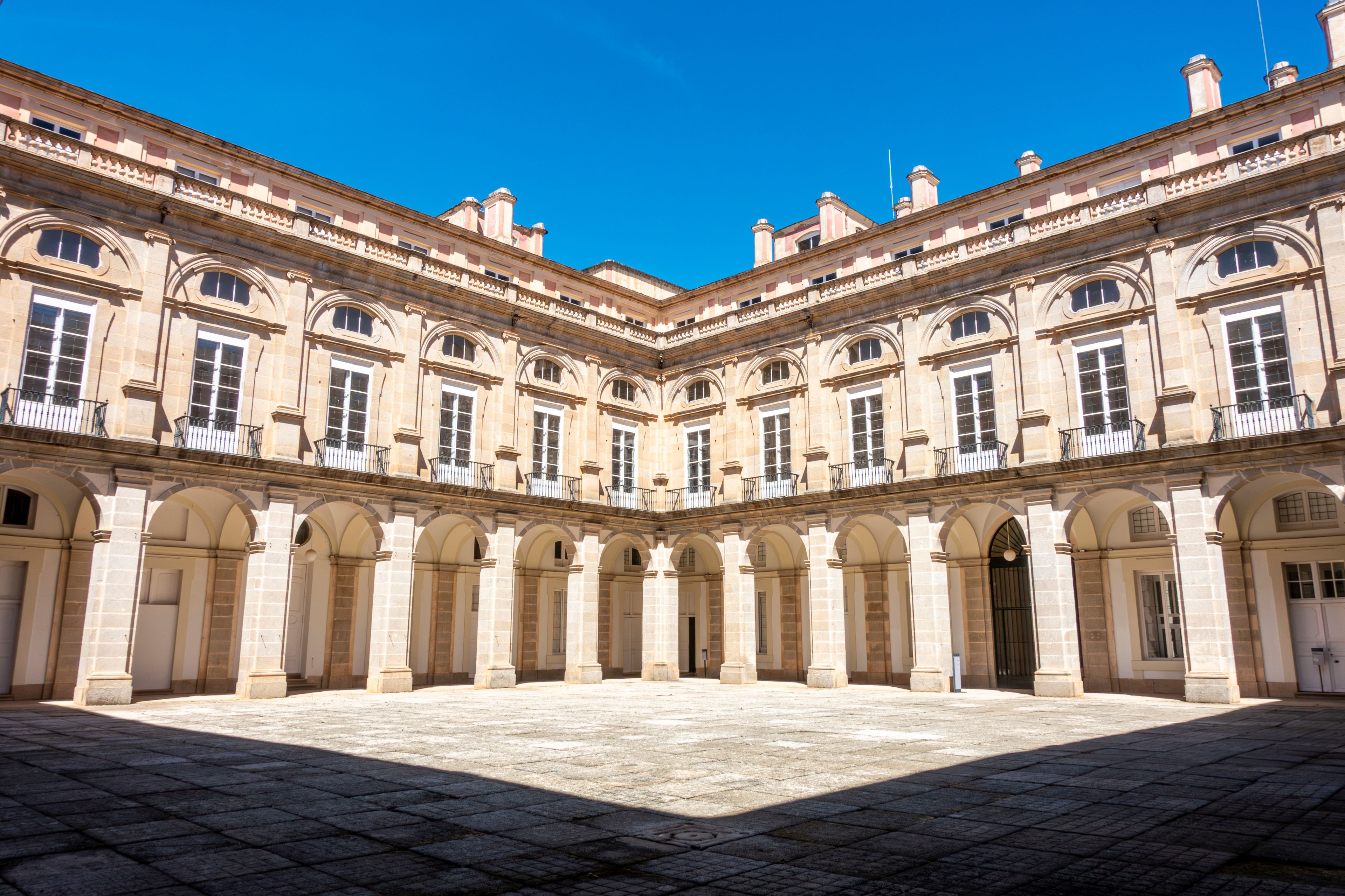 Un edifici gran i històric amb una façana simètrica, múltiples arcs i un pati central.