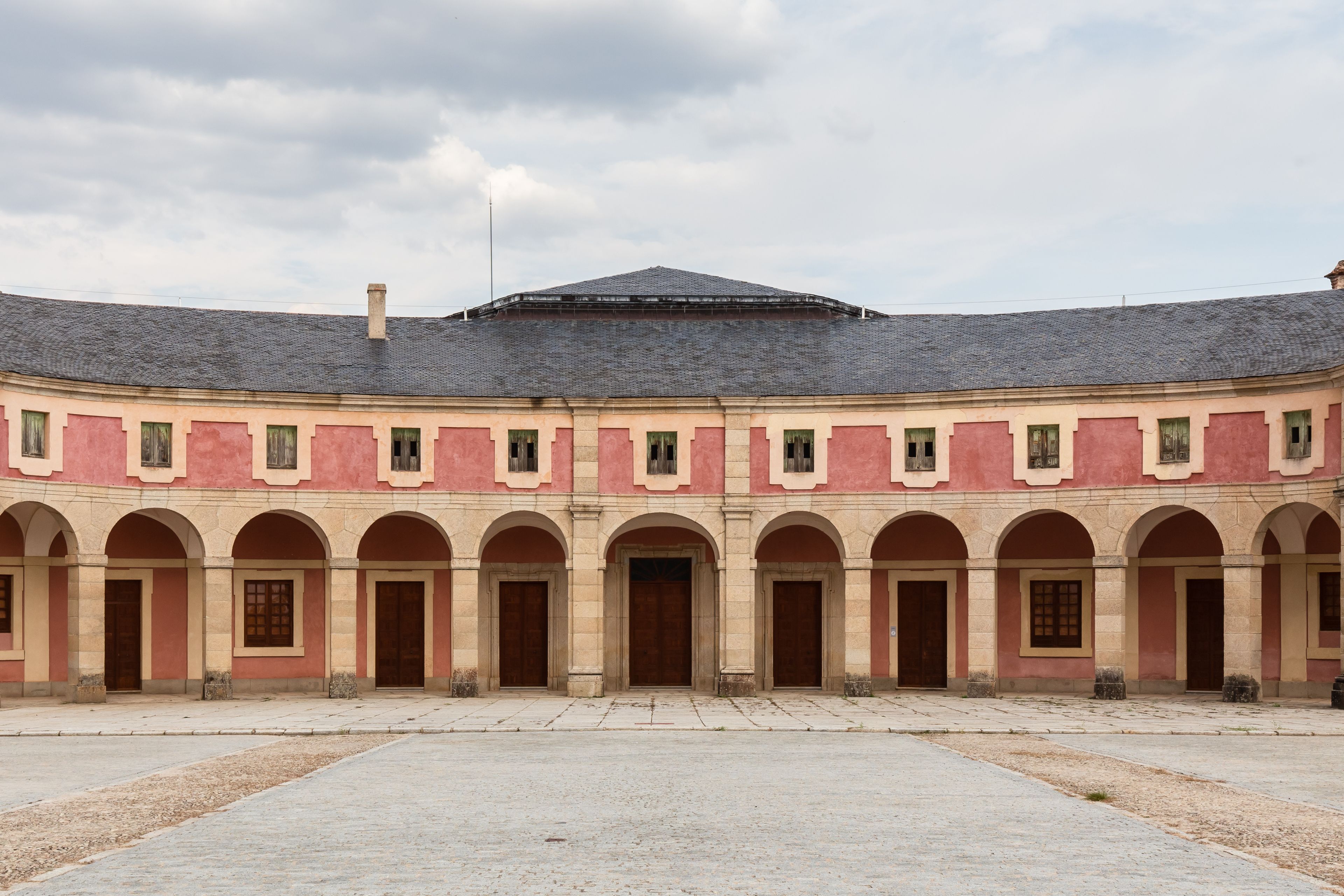 Un edifici històric amb façana corba, diverses voltes i teulat d'àmples rajoles.