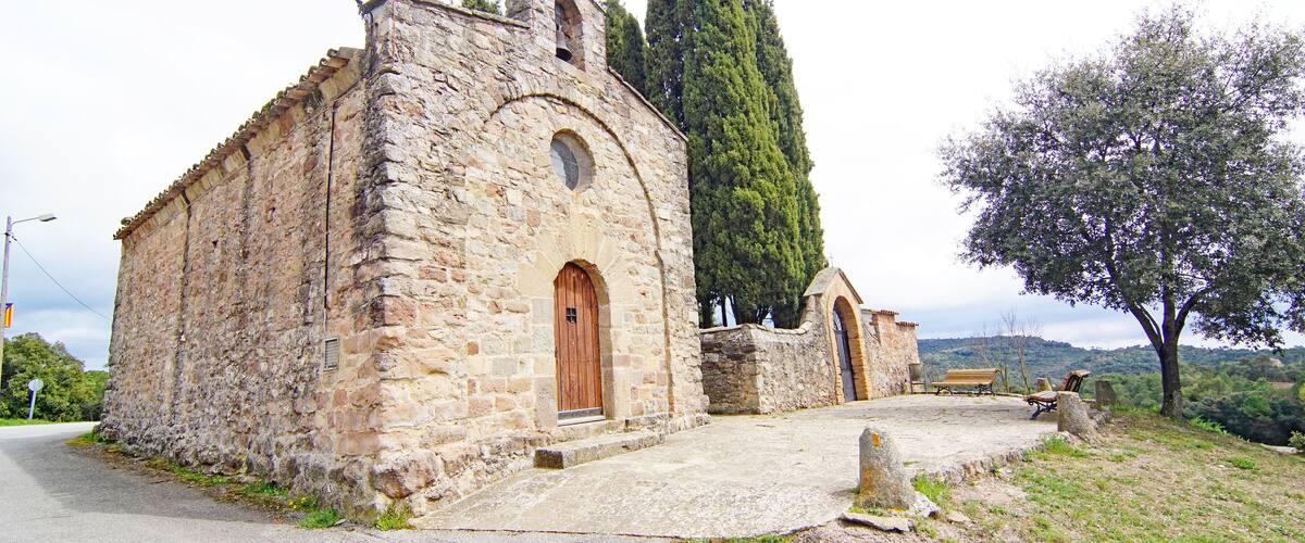 A stone church with a wooden door and a bell tower.