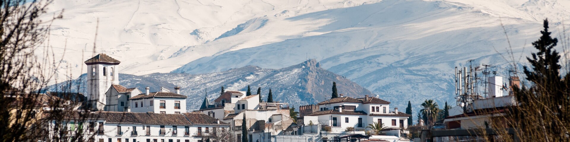 Una montaña nevada con un pueblo en primer plano.