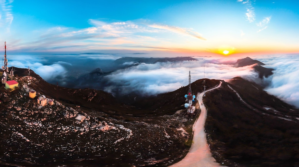 A mountain landscape with a road leading to a telecommunications tower.