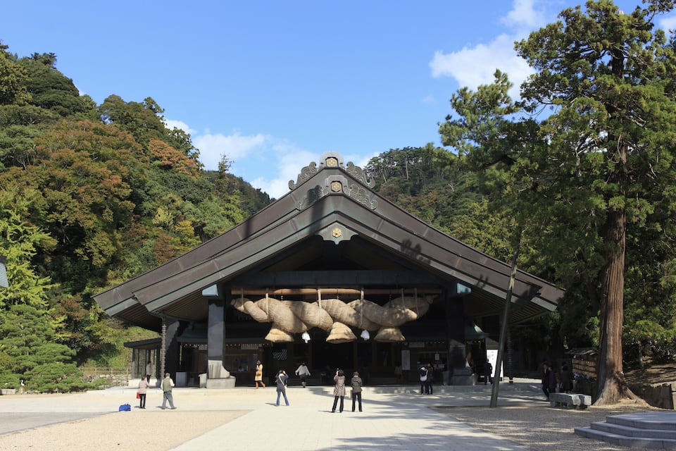 Un bâtiment traditionnel japonais doté d’une grande entrée et orné de décorations suspendues.