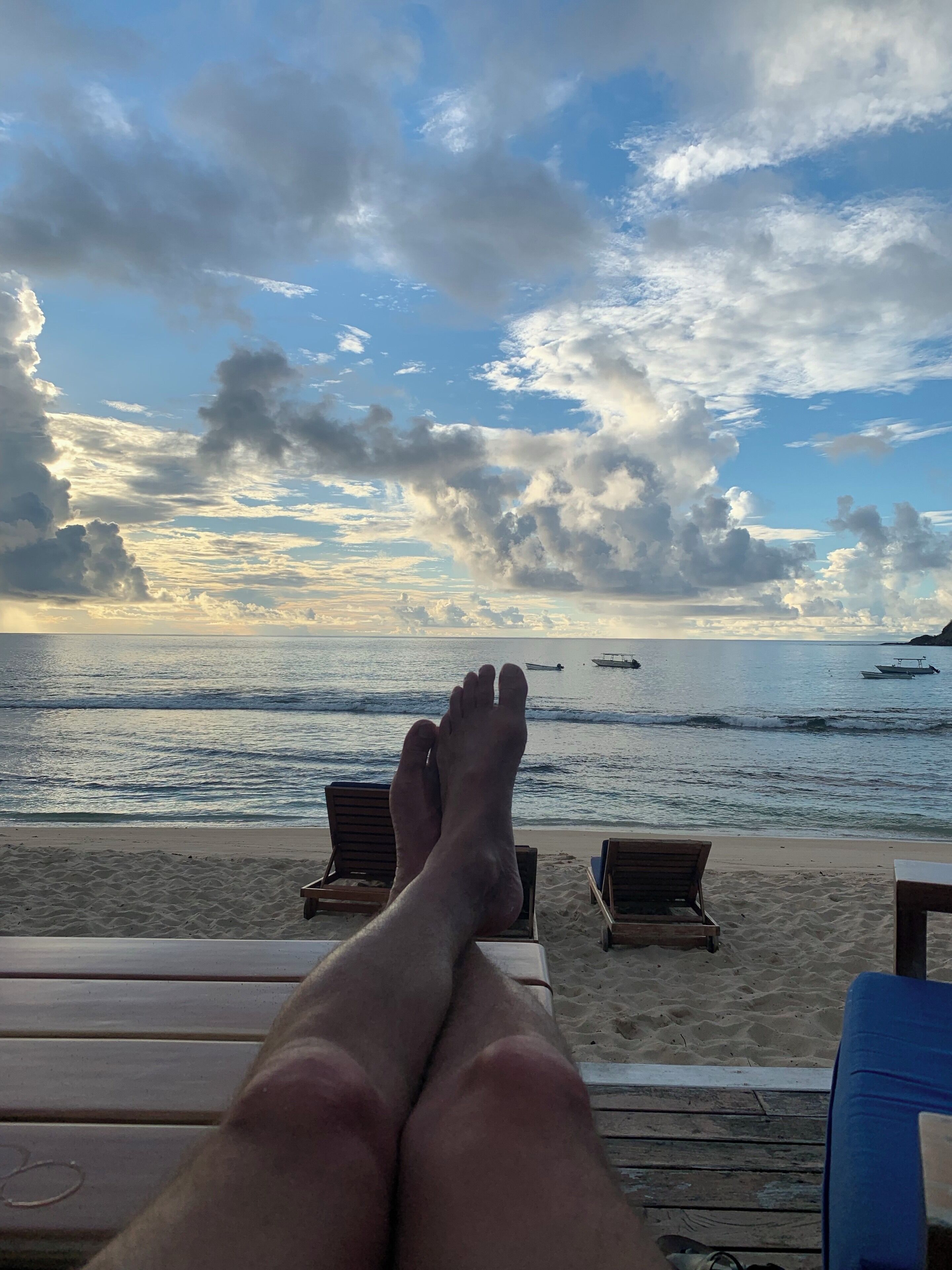 A beach with lounge chairs and a view of the ocean.