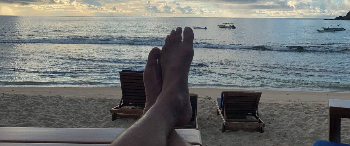 A beach with lounge chairs and a view of the ocean.