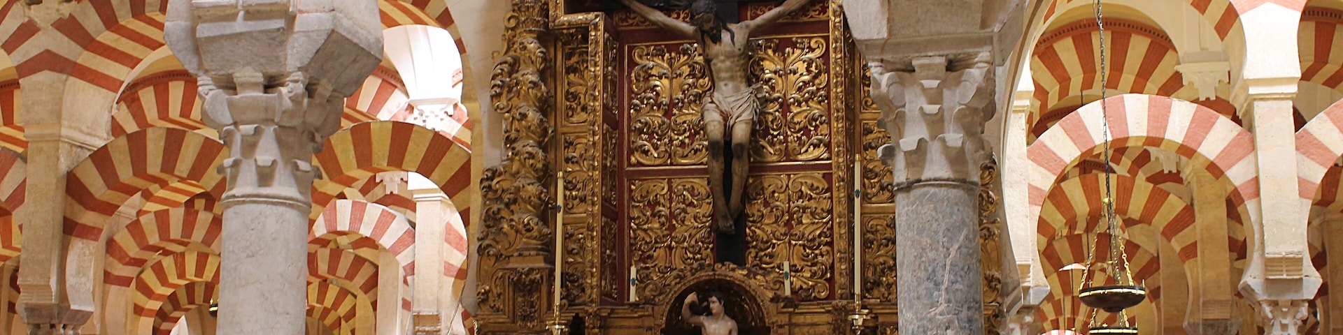 Statue du Christ au coeur de la Mezquita. Après la Reconquête, la mosquée est dédiée au culte catholique et, au XVIème siècle, les chrétiens élèvent une cathédrale gothique à l'intérieur, en plein milieu de ses arcs, incluant l'une dans l'autre et créant ainsi l'un des édifices les plus originaux qui soient au monde.