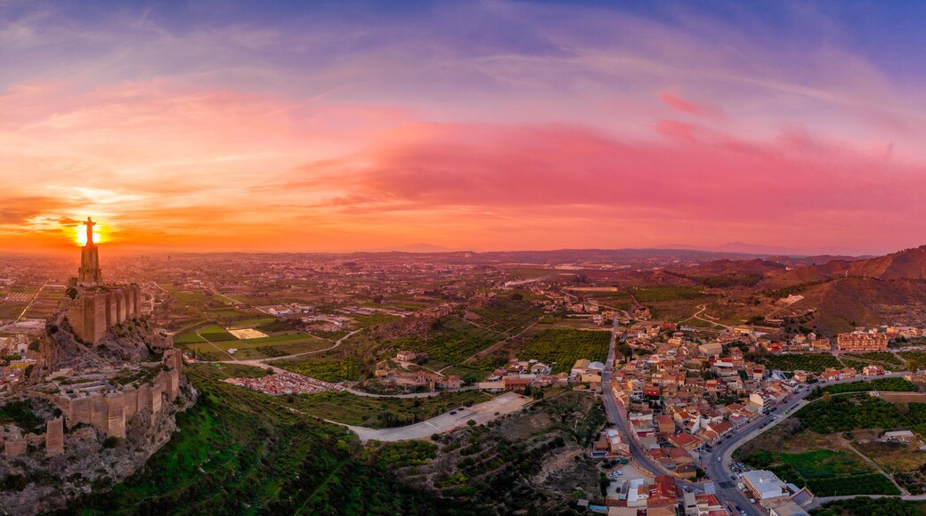 Monteagudo medieval castle ruin twelve rectangular towers circling the hilltop and the sacred heart of Jesus Christ statue on top near Murcia Spain