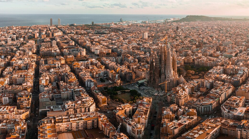 Aerial view of Barcelona City Skyline and Sagrada Familia Cathedral at sunset. Eixample residential famous urban grid. Cityscape with typical urban octagon blocks
