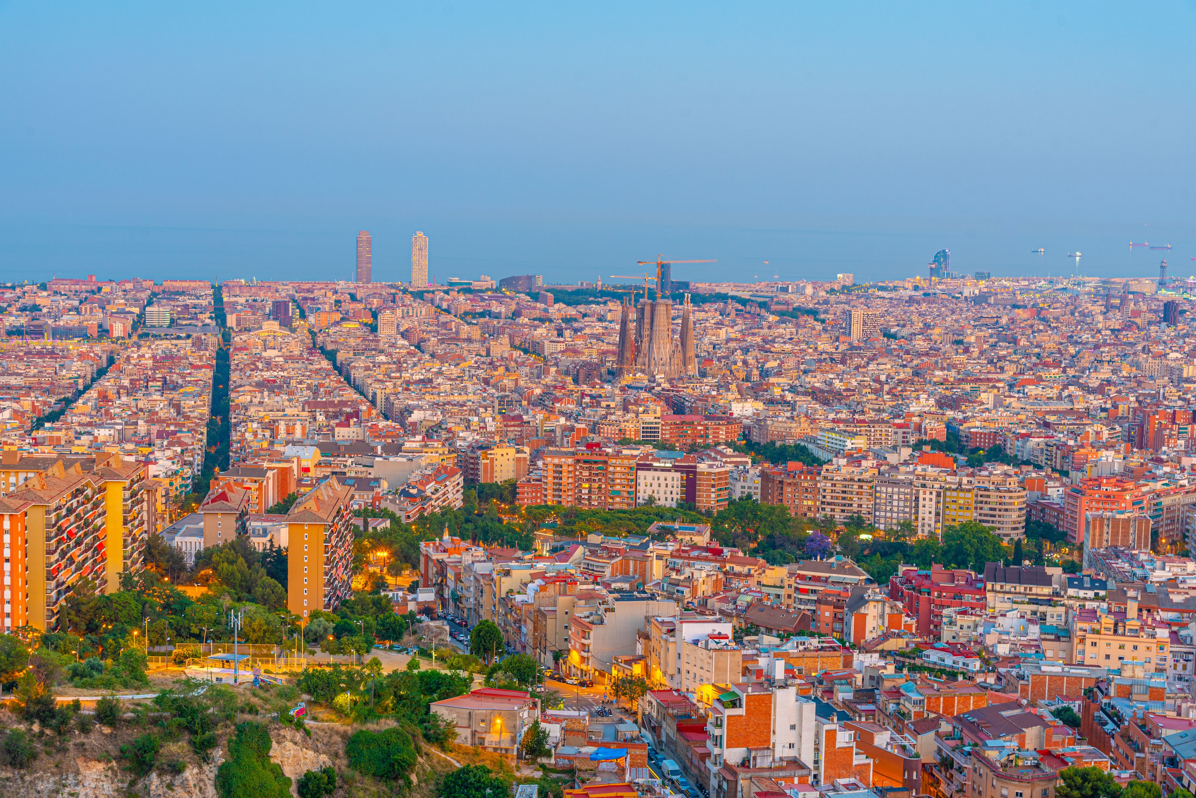 Una vista panorámica de una ciudad densamente poblada, con una catedral destacada y modernos rascacielos.