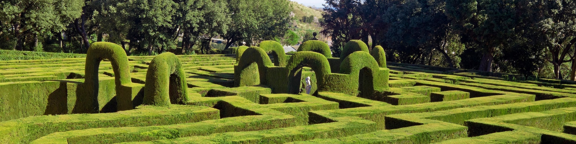 Un labyrinthe aux jardins parfaitement aménagés, avec des haies aux formes géométriques et des sculptures végétales.