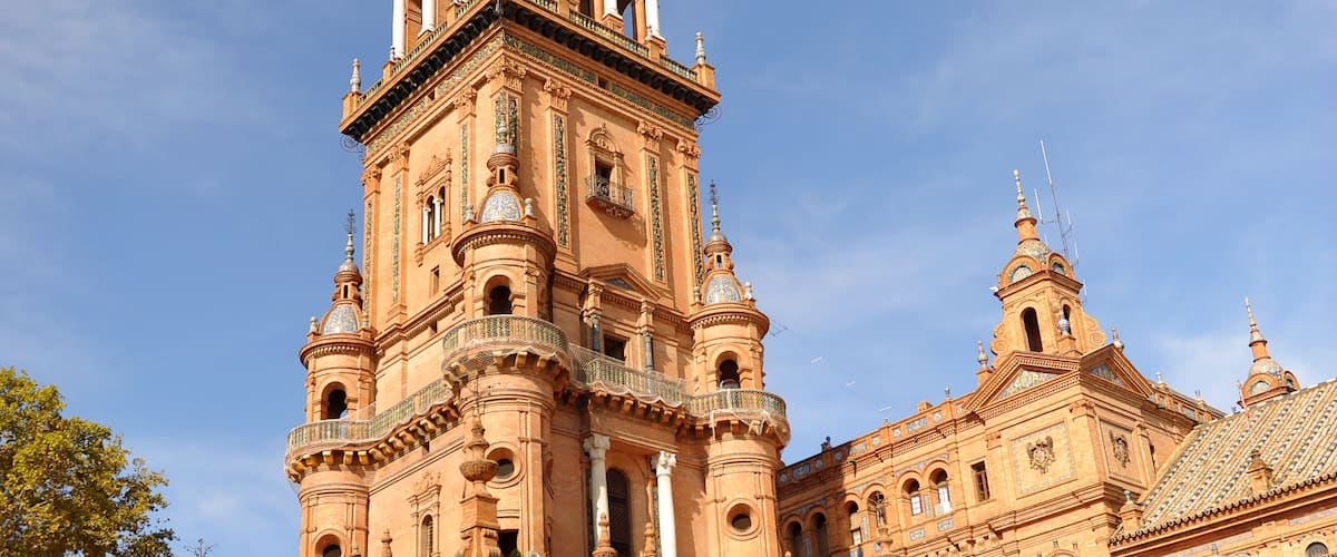 Edificio histórico con arquitectura ornamentada, que incluye una torre destacada y varios arcos.