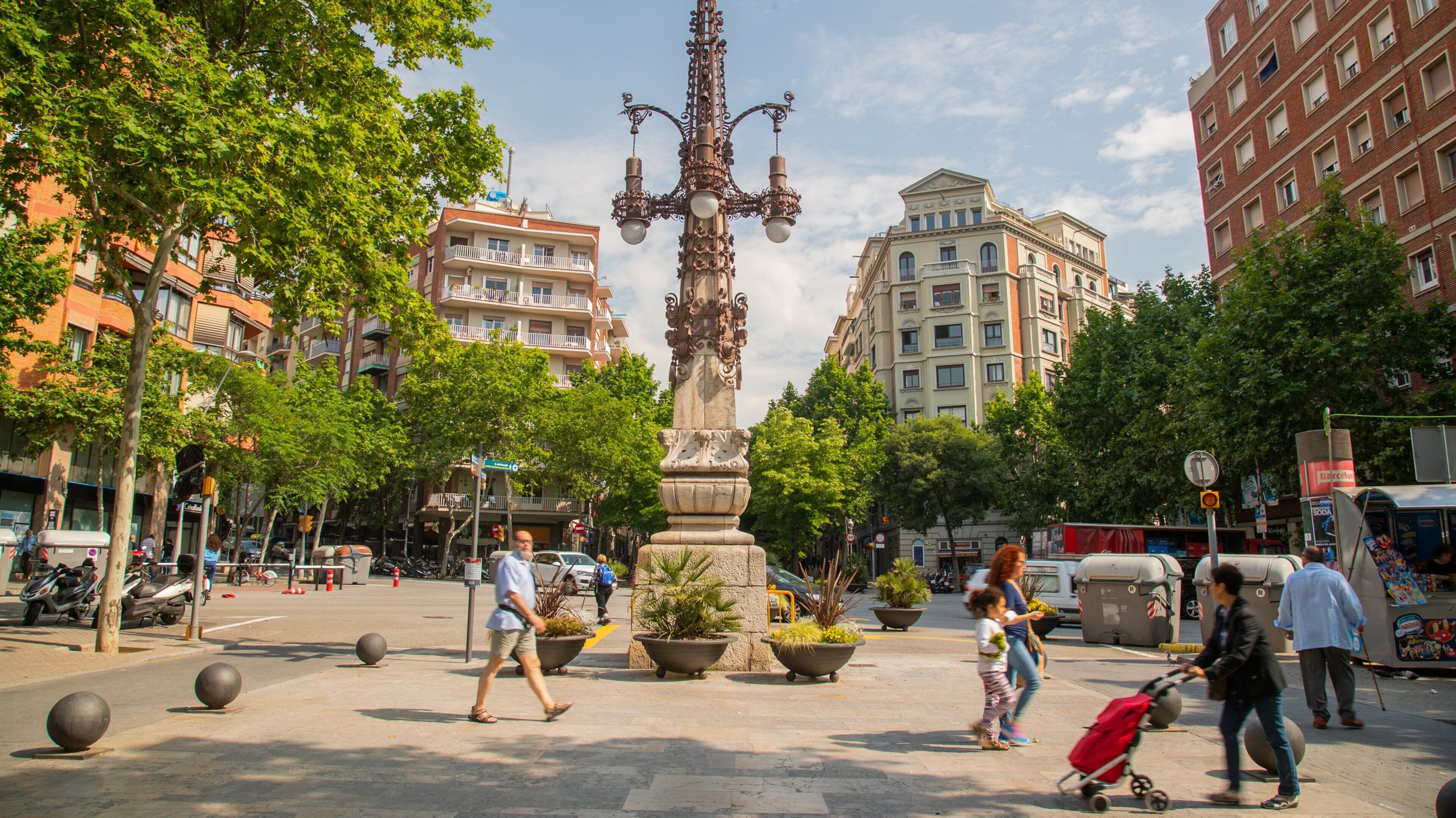 La Sagrada Familia showing outdoor art and street scenes as well as a small group of people