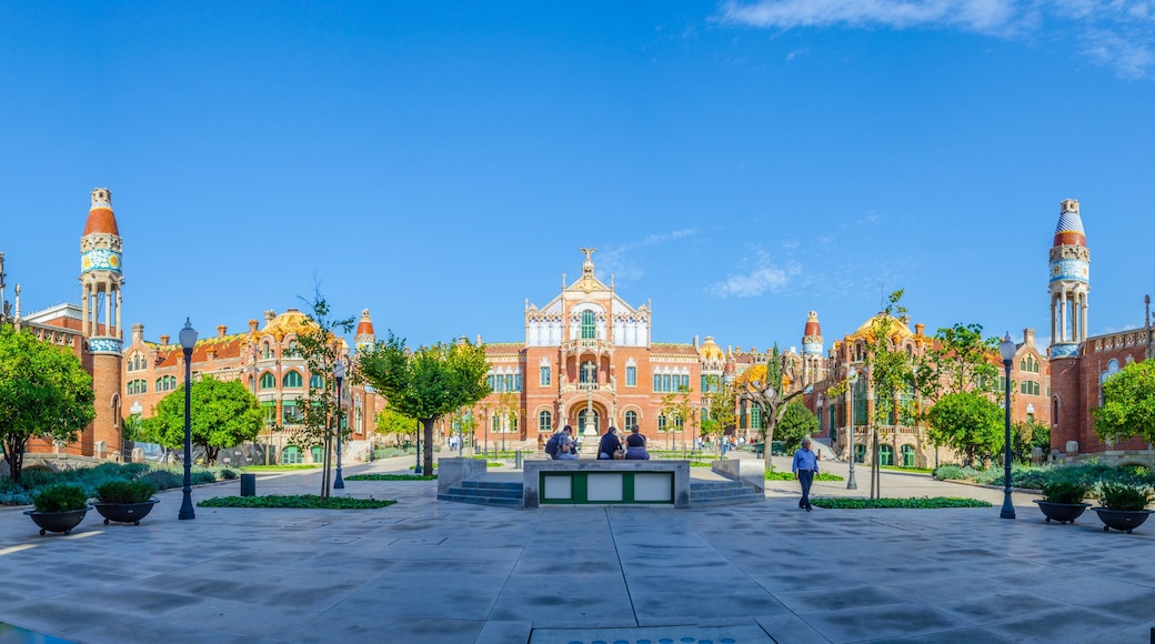 A plaza with a large building featuring ornate architecture and multiple towers.