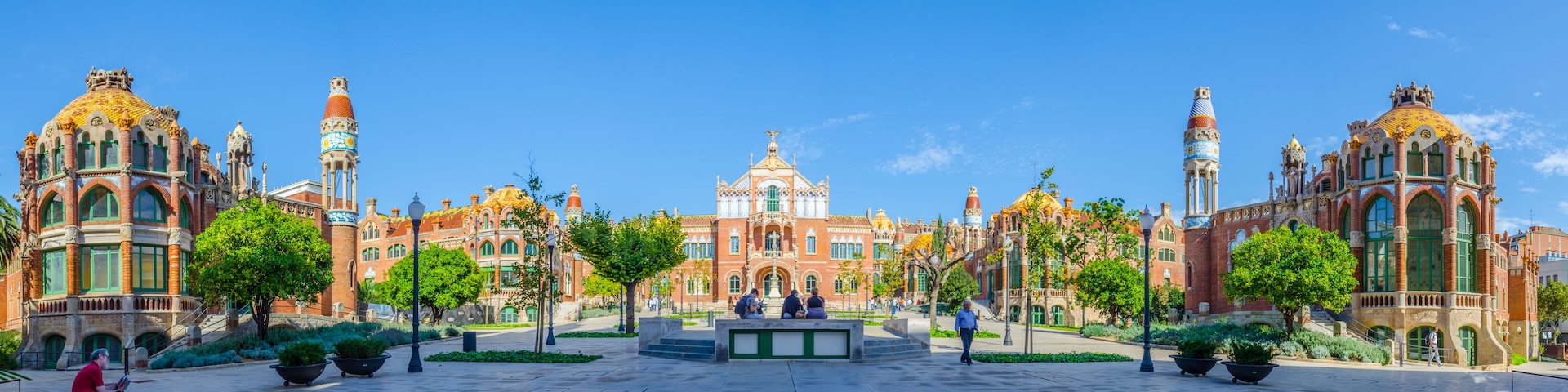 Una plaza con un edificio imponente de arquitectura ornamentada y varias torres.